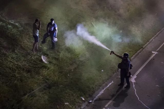 An officer releases pepper spray on demonstrators blocking I-94 near the Dale St. exit during a protest for Philando Castile in Falcon Heights, Minn. on Saturday July 09, 2016. Philando Castile was shot and killed after a traffic stop by police in Falcon Heights, Wednesday night. A video shot by Diamond Reynolds of the shooting went viral. (Photo by Jabin Botsford/The Washington Post)