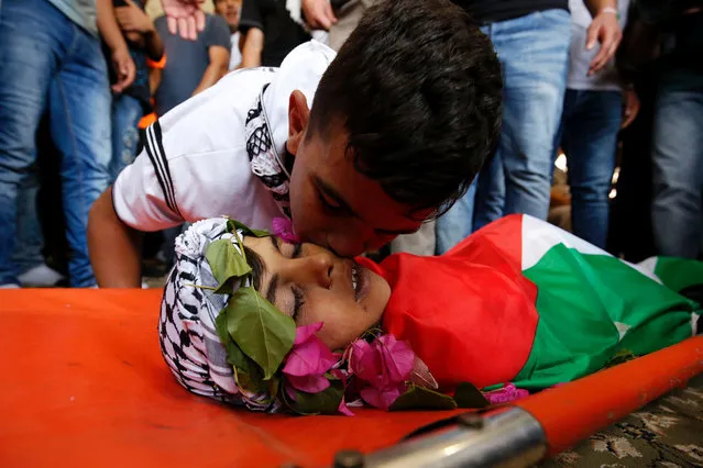 A Palestinian boy bids farewell to 12-year-old Mohiyeh al-Tabakhi, who was killed by Israeli soldiers who fired rubber-coated bullets near Jerusalem the day before, during his funeral in the Palestinian village of al-Ram, between Jerusalem and Ramallah in the Israeli occupied West Bank, on July 20, 2016. The boy was hit in the chest by a rubber-coated bullet which caused cardiac arrest, medical sources were quoted by the Palestinian news agency WAFA as saying. (Photo by Abbas Momani/AFP Photo)