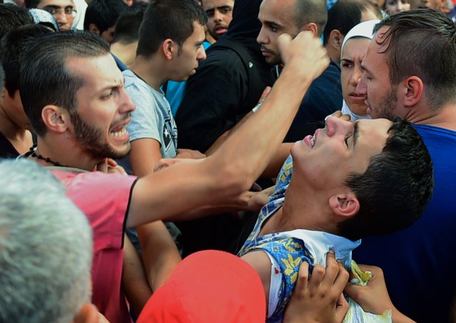 Migrants waiting for their trains fight in a massive crowd at the Eastern (Keleti) railway station of Budapest on September 1, 2015, during the evacuation of the railway station by local police. Budapest's main international railway station ordered an evacuation as hundreds of migrants tried to board trains to Austria and Germany, an AFP reporter at the scene said. (Photo by Attila Kisbenedek/AFP Photo)