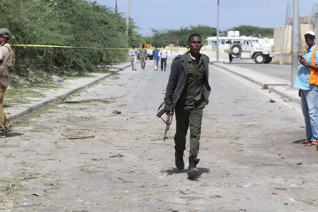 A policeman runs towards the scene of a suicide bombing near the African Union's main peacekeeping base in Mogadishu, Somalia, July 26, 2016. (Photo by Ismail Taxta/Reuters)