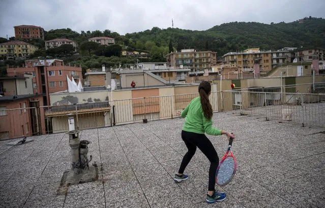 Vittoria Oliveri (front) plays tennis with Carola in background on rooftops of their house in Finale Ligure, Liguria Region, northwestern Italy on April 19, 2020, during the country's lockdown aimed at stopping the spread of the COVID-19 (new coronavirus) pandemic. Everyday Carola, 11, and Vittoria, 13, play tennis from a rooftop to another rooftop of their homes to practice during the Covid 19 lockdown. (Photo by Marco Bertorello/AFP Photo)