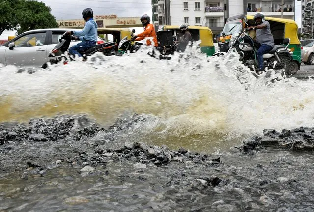 Traffic moves as water is pumped out of an inundated residential area following torrential rains in Bengaluru, India on September 7, 2022. (Photo by Samuel Rajkumar/Reuters)