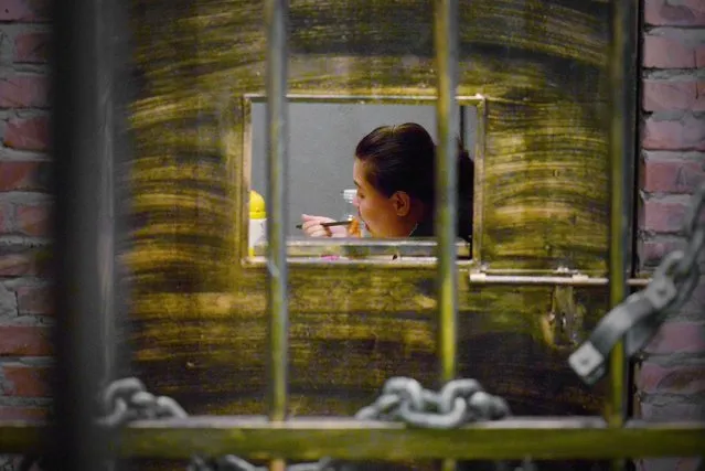 This picture taken on September 9, 2014 shows a woman having her dinner at a prison themed restaurant in Tianjin. (Photo by Wang Zhao/AFP Photo)