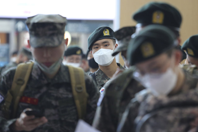 Military soldiers wearing face masks line up to buy train tickets as they are allowed to go on leave after more than two months of restrictions during heightened concerns of the coronavirus pandemic at the Seoul Railway Station in Seoul, South Korea, Friday, May 8, 2020. South Korean officials sounded alarms Friday after finding more than a dozen coronavirus infections linked to club goers in the densely populated Seoul metropolitan area. (Photo by Ahn Young-joon/AP Photo)