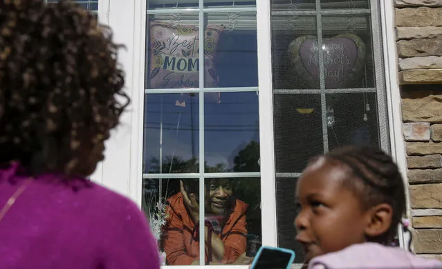 Mary Washington, 73, speaks through a window to her daughter, Courtney Crosby and grandchild Sydney Crosby for a Mother's Day celebration at Provident Village at Creekside senior living on Sunday, May 10, 2020, in Smyrna, Ga. (Photo by Brynn Anderson/AP Photo)