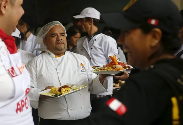 Inmates carry platters of food during a culinary competition at the Santa Monica female prison in Lima, September 10, 2015. (Photo by Mariana Bazo/Reuters)