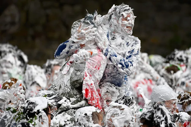 Students from St. Andrew's University indulge in a tradition of covering themselves with foam to honor the “academic family” on the lower college lawn on October 23, 2017, in St Andrews, Scotland. (Photo by Jeff J. Mitchell/Getty Images)