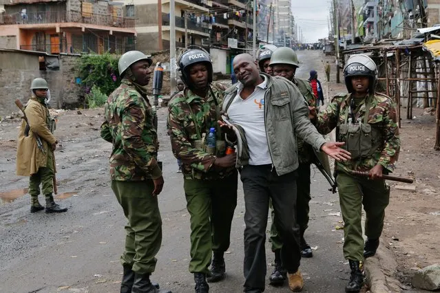 Anti-riot police officers arrest a man believed to be a protester as they engaged supporters of the opposition coalition, the National Super Alliance (NASA) and its presidential candidate Raila Odinga, during their protest in Mathare slum, one of the opposition strongholds in Nairobi, Kenya, 26 October 2017. Kenyans are casting their votes in the repeat presidential poll but in opposition strongholds Odinga'supporters disrupted the voting process, engaging in running battles with police. Odinga chose not to contend after he lost faith in the Independent Electoral and Boundaries Commission (IEBC), following his victory in the Supreme Court of Kenya nullifying the first election in August 2017. (Photo by Daniel Irungu/EPA/EFE)