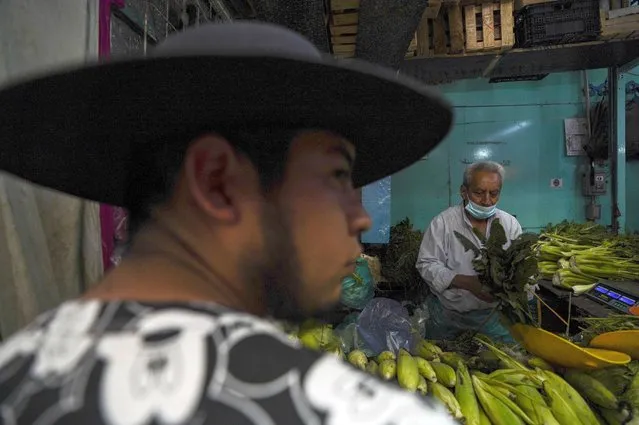 A man shops for vegetables at a market in Mexico City, Tuesday, August 9, 2022. Mexico's annual inflation rate rose to 8.15% in July, driven largely by the rising price of food, according to government data released Tuesday. (Photo by Fernando Llano/AP Photo)