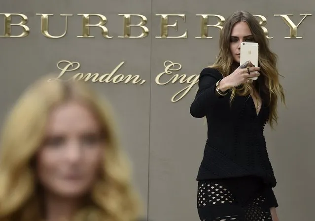 British model Cara Delevingne takes a selfie as she arrives for the Burberry Spring/Summer 2016 collection during London Fashion Week September 21, 2015. (Photo by Toby Melville/Reuters)