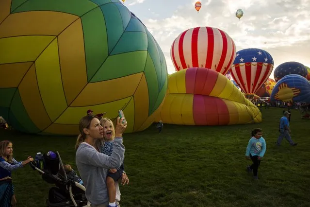 Attendees watch and take pictures as hundreds of hot air balloons lift off on the first day of the 2015 Albuquerque International Balloon Fiesta in Albuquerque, New Mexico, October 3, 2015. (Photo by Lucas Jackson/Reuters)