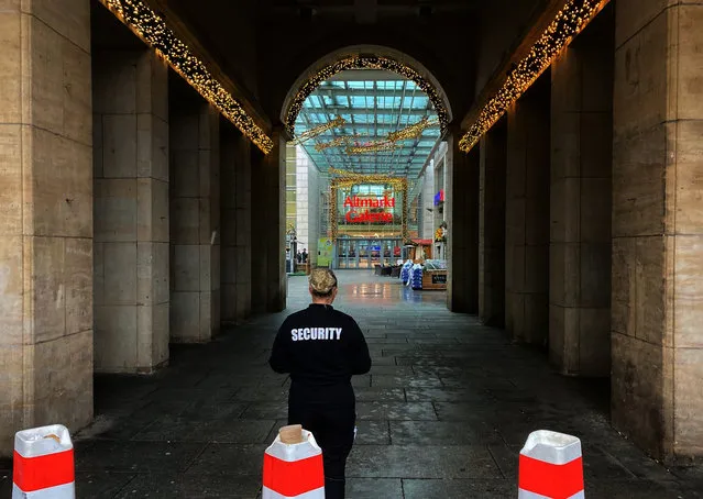 An employee of a security company stands near the Altmarktgalerie after a hostage situation in Dresden, Germany, Saturday December 10, 2022. German police say they have ended a hostage situation in the eastern city of Dresden after there were reports of shots fired. Police had urged people to avoid an area in the city center on Saturday morning while the operation was underway. (Photo by Jorg Schurig/dpa via AP Photo)