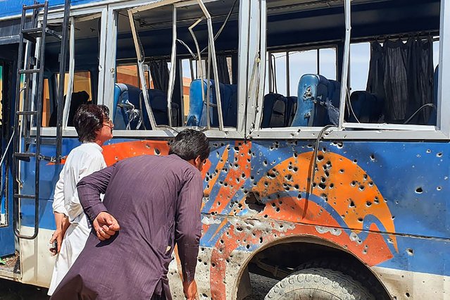 People look at a damaged police bus parked in a security compound following a bomb explosion in Mastung district on April 15, 2025. An explosion targeting a police bus in Pakistan's southwestern Balochistan province killed at least three officers and wounded 16 others on April 15, authorities said. (Photo by AFP Photo/Stringer)