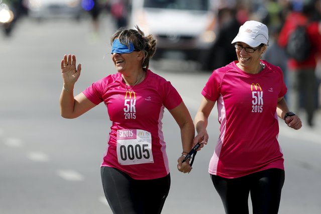 Laura Paipo (L), first blind principal in Uruguay participates in a street race with her sighted guide and friend Amparo Bauter in Montevideo, October 4, 2015. (Photo by Andres Stapff/Reuters)