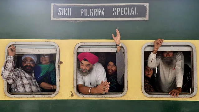 Indian Sikh pilgrims wave from a train bound for Pakistan at the Attari International Railway Station, about 35 kms from Amritsar, on November 4, 2014. Thousands of Sikh pilgrims are travelling to Nankana Sahib in Pakistan to celebrate the 545th birth anniversary of Sri Guru Nanak Dev which falls on November 6. (Photo by Narinder Nanu/AFP Photo)