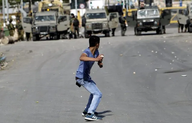 A Palestinian protester hurls stones at Israeli troops during clashes in the West Bank city of Jenin October 9, 2015. (Photo by Mohammed Ballas/Reuters)