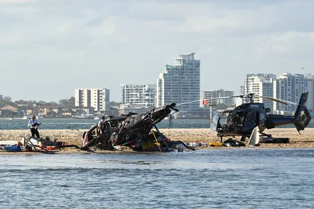 Police inspect a helicopter at the scene of a helicopter collision near Seaworld, on the Gold Coast, Australia, 02 January 2023. Four people are dead and another 13 injured after two helicopters collided before one crashed into the Broadwater on the Gold Coast. (Photo by Dave Hunt/EPA/EFE)