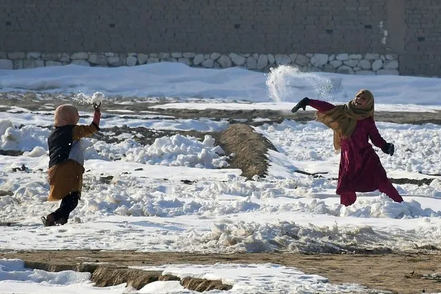 Afghan internally-displaced children play with snow near their tents during a cold winter day at Nahr-e Shah-e- district of Balkh Province, near Mazar-i-Sharif on January 17, 2023. (Photo by Atif Aryan/AFP Photo)