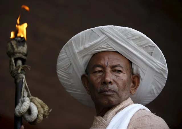 A priest holding "Chirag", a traditional lamp, takes part during a deity's procession as part of the Shikali festival at Khokana village in Lalitpur, Nepal October 19, 2015. (Photo by Navesh Chitrakar/Reuters)