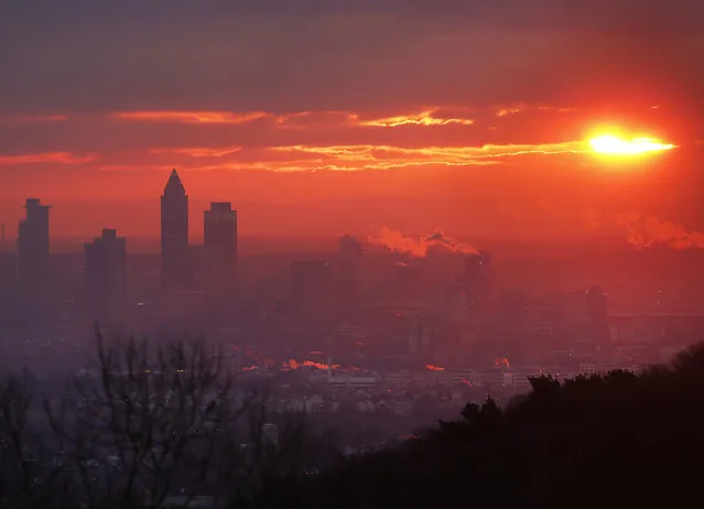 The sun rises over the buildings of the banking district in Frankfurt, Germany, Friday, December 29, 2017. (Photo by Michael Probst/AP Photo)