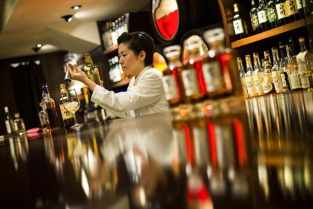 A bartender pours Yamazaki whisky at the Hibiya whisky bar in the Ginza district in Tokyo December 2, 2014. (Photo by Thomas Peter/Reuters)