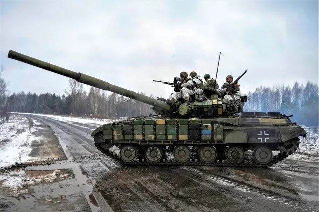 Ukrainian servicemen ride atop of a tank during drills of armed forces at the border with Belarus, amid Russia's attack on Ukraine, near Chornobyl, Ukraine on February 3, 2023. (Photo by Viacheslav Ratynskyi/Reuters)