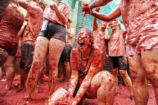 Revelers throw tomatoes at each other during the annual “Tomatina” tomato fight fiesta, in the village of Bunol near Valencia, Spain, Wednesday, August 27, 2025. (Photo by Alberto Saiz/AP Photo)