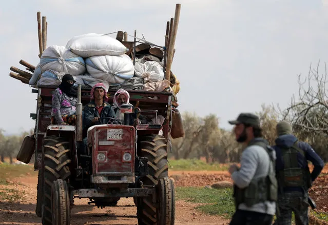 Internally displaced people ride with their belongings in the town of Inab, eastern Afrin, Syria March 14, 2018. (Photo by Khalil Ashawi/Reuters)