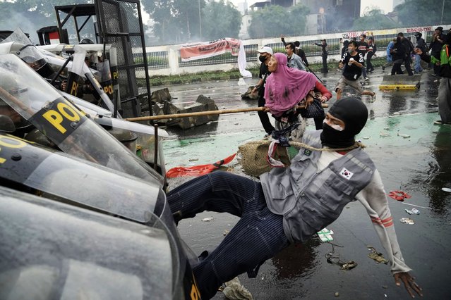 Protesters clash with riot police during a protest against lavish allowances given to parliament members, in Jakarta, Indonesia, Thursday, August 28, 2025. (Photo by Tatan Syuflana/AP Photo)