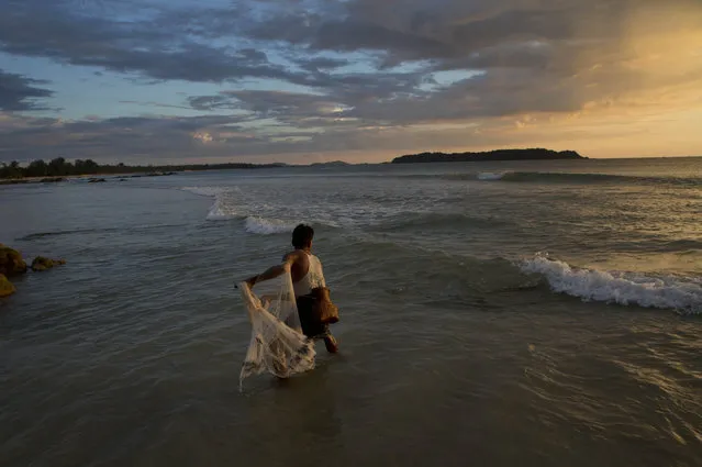 A fisherman throws a net to catch fish in the shallow waters of Ngapali beach in Myanmar's western Rakhine State at dusk, Thursday, October 15, 2015. (Photo by Gemunu Amarasinghe/AP Photo)