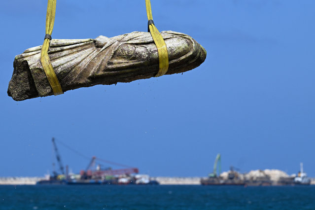A crane pulls an artifact from the waters at Abu Qir bay in Alexandria on August 21, 2025, as part of an event organized by the Ministry of Tourism and Antiquities to recover sunken antiquities. (Photo by Khaled Desouki/AFP Photo)