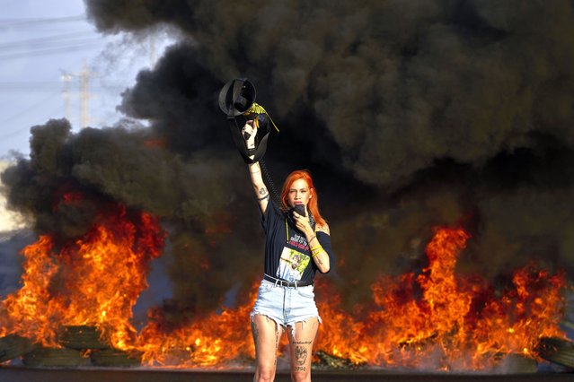 An activist blocks a highway during a protest demanding the immediate release of hostages held by Hamas and calling for the Israeli government to reverse its decision to take over Gaza City and other areas in the Gaza Strip, near the city of Lod, Israel, Tuesday, August 26, 2025. (Photo by Ohad Zwigenberg/AP Photo)