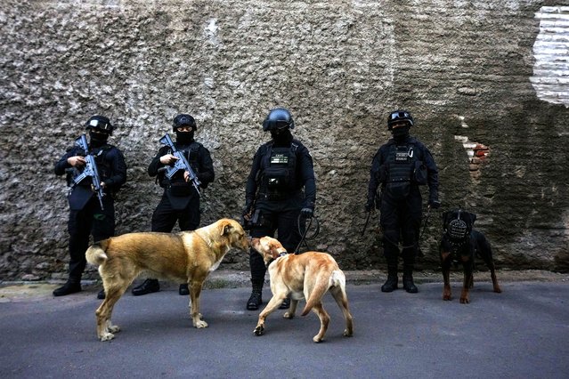 Police stand guard before a press conference on the extradition of “Tren de Aragua” gang members from the United States, at the a high-security prison where they are being held in Santiago, Chile, Wednesday, October 1, 2025. (Photo by Esteban Félix/AP Photo)
