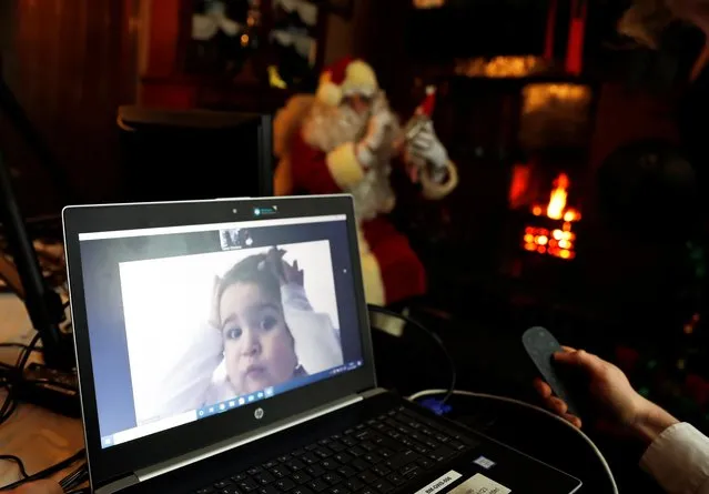 Pippa Hunt, 4, from Washington, County Durham, reacts as she receives a live video call from Santa Claus, who is fireside at the Edwardian cottage at Beamish Museum in Beamish, County Durham, Britain on December 10, 2020. (Photo by Lee Smith/Reuters)