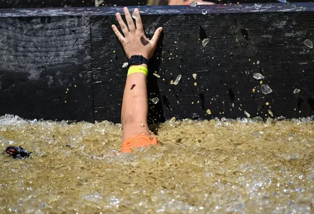 Competitors take part in “Tough Mudder” at the Glen Helen Raceway in San Bernardino, California, United States on April 2, 2023. Tough Mudder is an endurance event series in which participants attempt 3-6-9 mile-long (5K-10K-15K) obstacle courses featuring steep inclines, water hazards and military-style obstacles testing one's toughness, fitness, strength, stamina and mental grit. (Photo by Tayfun Coskun/Anadolu Agency via Getty Images)