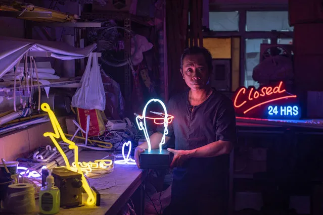In this picture taken on April 16, 2018, neon sign maker Wu Chi- kai poses during an interview with AFP in Hong Kong Neon sign maker Wu Chi- kai is one of the last remaining craftsmen of his kind in Hong Kong, a city where darkness never really falls thanks to the 24- hour glow of a myriad lights. Ahead of May Day, AFP' s video and photo teams spoke to men and women around the globe whose jobs are becoming increasingly rare, particularly as technology transforms societies. (Photo by Philip Fong/AFP Photo)