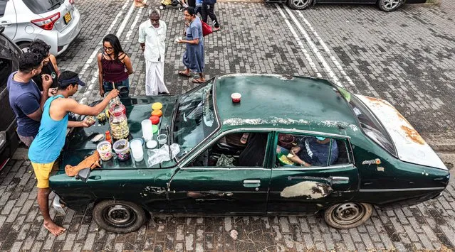 On the Phone – Bonnet Delights. Saturday afternoon street food in Galle Fort, Sri Lanka. (Photo by Hein vanTonder/Pink Lady Food Awards 2023)