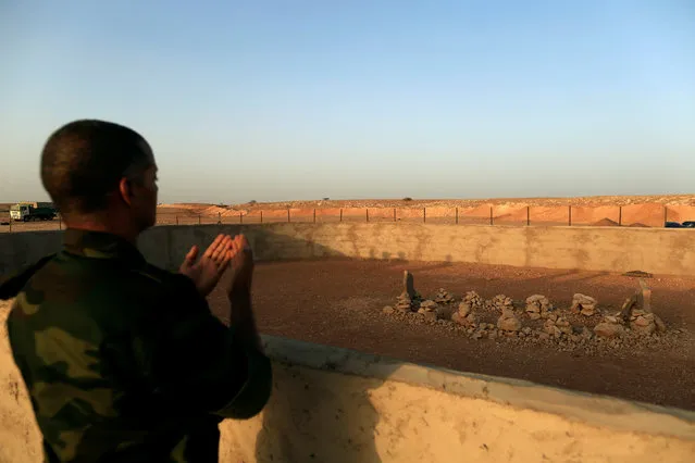 The Polisario Front officer prays at the grave of the late Western Sahara's Polisario Front President Mohammed Abdelaziz in Bir Lahlou, Western Sahara, September 9, 2016. (Photo by Zohra Bensemra/Reuters)