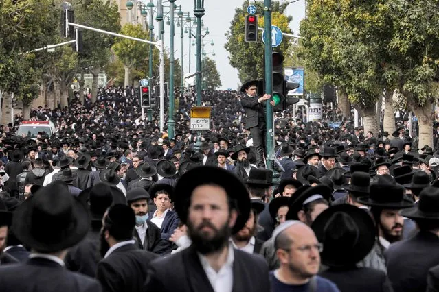 Ultra-Orthodox Jewish mourners gather to attend the funeral of Haredi rabbi Chaim Kanievsky in the Israeli city of Bnei Brak near Tel Aviv, on March 20, 2022. An estimated three quarters of a million ultra-Orthodox Jews on March 20 attended the funeral of the influential rabbi, known to followers as the “Prince of Torah”, with Israeli authorities warning of dangers from massive overcrowding. Kanievsky, who died two days earlier at the age of 94, was a key figure among the ultra-Orthodox Jewish community. (Photo by Gil Cohen-Magen/AFP Photo)