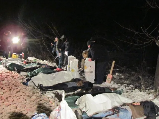 In this picture taken late Tuesday, January 13, 2015, the bodies of the victims of a shelling attack on a passenger bus near the eastern Ukraine town of Volnovakha are laid out by the side of the road. (Photo by Mykola Ryabchenko/AP Photo)