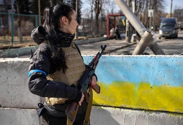 A volunteer takes position at a checkpoint in a district in Kyiv, on March 20, 2022. A shell exploded outside an apartment block in Kyiv, wounding five people, the mayor said Sunday, the latest bombardment as Russian forces try to encircle the Ukranian capital. (Photo by Fadel Senna/AFP Photo)