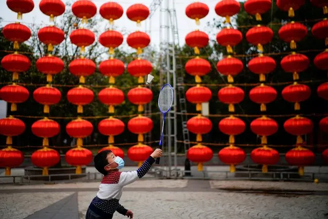 A boy wearing a face mask plays badminton at a street decorated for Lunar New Year celebrations in Wuhan, Hubei province, China on February 8, 2021. (Photo by Aly Song/Reuters)