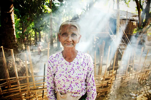 “Grandmother”. This is a portrait of a grandmother from a Chin Village near Mrauk U. This women showed me around her village and told me the story of her tattoo that she received when she was a teenager, once a right of passage. Eventually these tattoos were banned in the state and the grandmothers are the only ones left with these intricate designs on their faces. I stayed at the village till almost sunset, villagers began to burn fires to keep warm as the night air was quite cold as I was leaving I asked if I could take her portrait just as the sun was shining below and caught the smoke from the fires. Location: Chin Village, near Mrauk U, Myanmar. (Photo and caption by Sarah Baker/National Geographic Traveler Photo Contest)