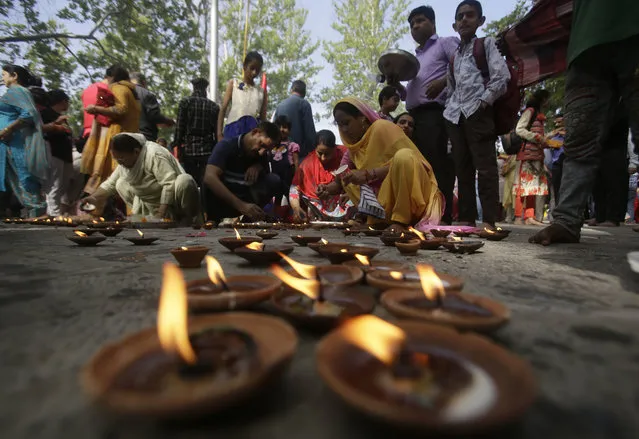Kashmiri Hindu devotees known as “pandits” light oil lamps ans offer prayers during the annual festival at the Kheer Bhawani temple in Tul Mul, outskirts of Srinagar, India, Wednesday, June 20, 2018. Hundreds of thousands of Hindus had abandoned the valley for Hindu-dominated areas farther south after the separatist insurgency erupted in 1989. A few families stayed behind to look after ancestral farmlands or businesses. (Photo by Mukhtar Khan/AP Photo)