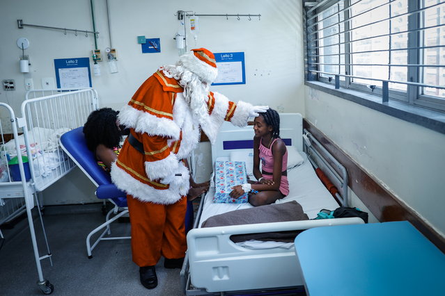 A man dressed as Santa Claus greets a child at the Souza Aguiar Municipal Hospital in Rio de Janeiro, Brazil, 19 December 2024. The Souza Aguiar Municipal Hospital, in collaboration with volunteers, held a Christmas campaign visiting hospitalized children and giving them gifts. (Photo by Andre Coelho/EPA)