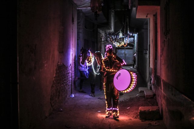 Mohammed Al-Dahshan, who decorates himself and his horse with led lights, performs the Ramadan drumming on the north of the Egyptian capital Cairo on March 20, 2025. Al-Dahshan and his horse hit the road at sahur (Ramadan meal eaten at night) time, wandering the streets of Dekernes region every night during Ramadan and waking people up for sahur. (Photo by Mohamed Elshahed/Anadolu via Getty Images)