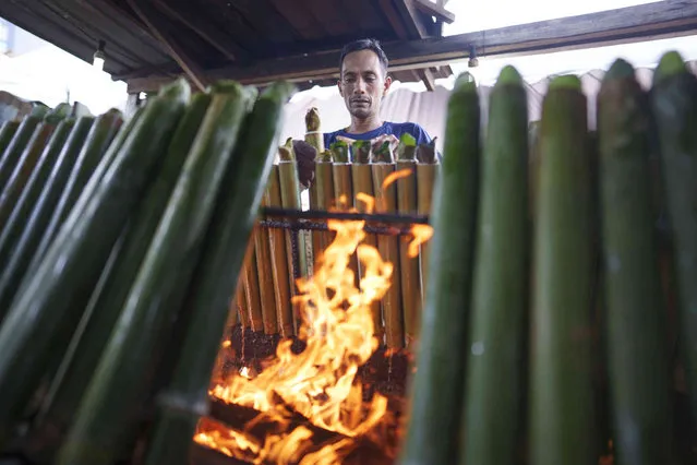A Malaysian Muslim vendor cooks “lemang”, a traditional food of glutinous rice stuffed in bamboo sticks and cooked over charcoal fire, ahead of the Eid al-Fitr celebrations in Kuala Lumpur, Malaysia, Friday, April 21, 2023. (Photo by Vincent Thian/AP Photo)