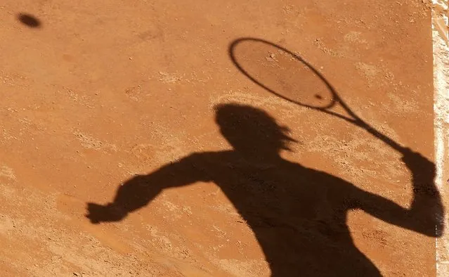 Rafael Nadal of Spain casts a shadow on the ground as he serves to Marsel Ilhan of Turkey during their second round match at the Rome Open tennis tournament in Rome, Italy May 13, 2015. (Photo by Max Rossi/Reuters)