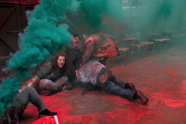 Activists from Palestine Action let off smoke grenades, spray blood red paint and grapple with a security guard (black coat & white shirt) while obstructing the entrance to the offices of Elbit Systems on May 31, 2022 in the Holborn area of London, England. (Photo by Guy Smallman/Getty images)