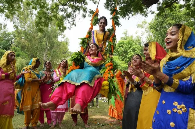 College students wearing traditional Punjabi attires celebrate the “Teej” festival in Amritsar on August 4, 2023. (Photo by Narinder Nanu/AFP Photo)